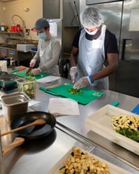 volunteer mentor Aidan, left, and his mentee, right, cooking