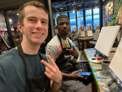volunteer mentor Aidan, left, and his mentee, right, at a paint night event