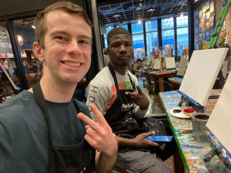 Aidan, left, and his mentee, right, at a paint night event