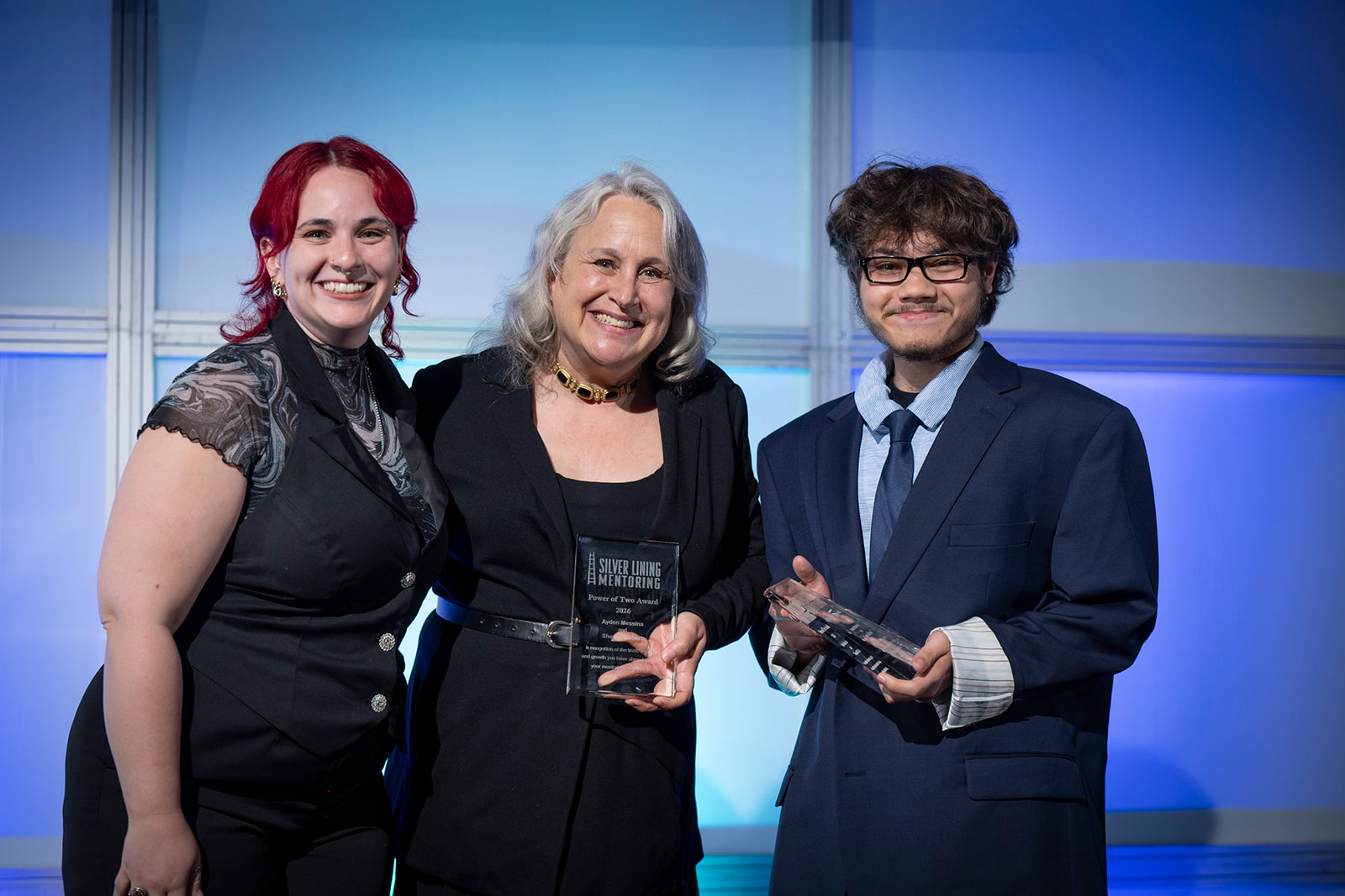 Silver Lining Mentoring MATCH GALA Mentee Ayden and mentor Shayne smiling on stage while accepting the Power of Two Award.