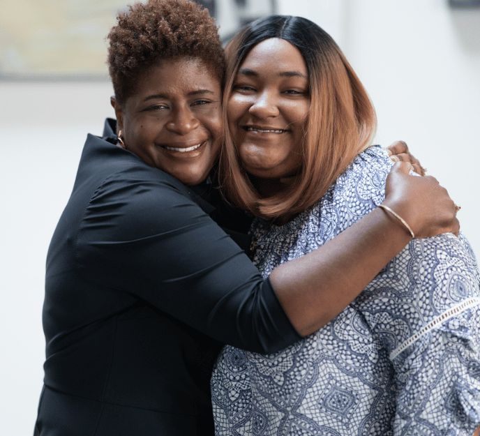 A mentor and mentee sharing a hug